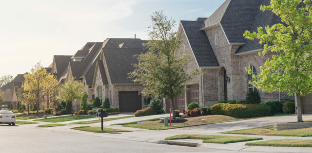 Panorama view new development neighborhood near Dallas, Texas, America. Brand new house curbside front yard sidewalk pathway and well trimmed landscape in early springtime. Sunny cloud blue sky