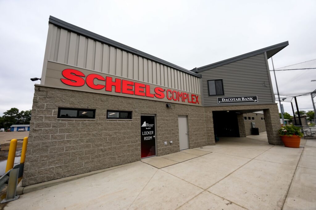 Exterior shot of the main building at the Scheels complex for baseball and softball diamonds. Locker room door leads into a brick-and-mortar structure.