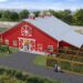 Aerial rendering of a bright red barn with a metal roof surrounded by outdoor animal enclosures and a green tractor.